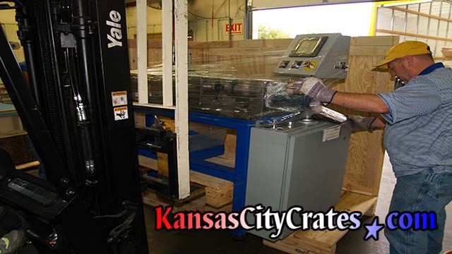 Stamping press wrapped and loading into industrial crate for international shipping