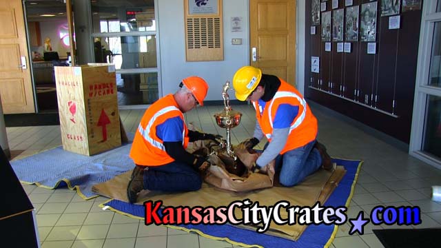 Kansas City Crates Safety Director and Project Manager wrap title trophy at Vanier Sportrs Complex before stadium demolition in full Personal Protective Equipment dress
