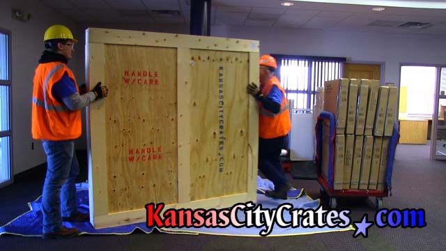 Crate personnel move hevy duty vault crate wearing steel toe boots, hard hats, safety glasses and cut resistant gloves