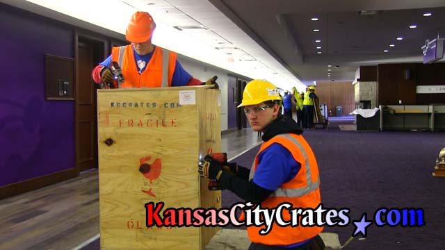 Safety director of Kansas City Crates closing crate wearing eye protection, gloves and hard hat