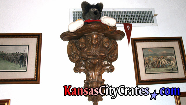 Full size view of antique wood Putti pedestal holding collector doll on wall in Kansas City Mansion.