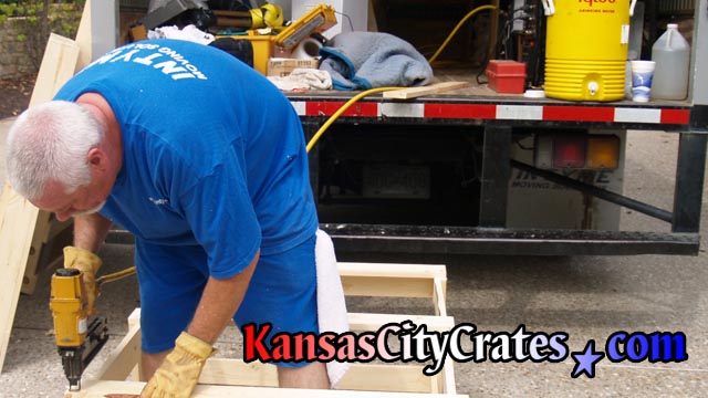 Professional assembly of crates on-site with commercial equipment.
