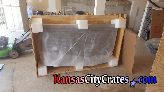 Samsung curved television packed in solid wall crate with large foam blocks protecting corners and supporting bottom