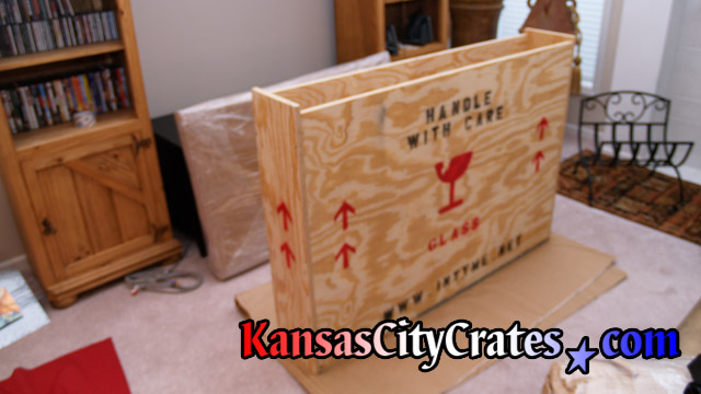 Crate sitting on carboard in carpeted home for flat panel tv.