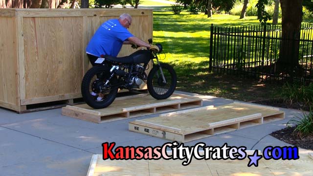 Loading restored vintage motorcycle onto crate pallet