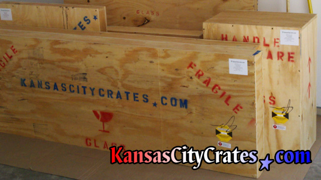 Solid wall wood crates with shipping symbols and shockwatch indicators staged on flooring protection for laoding at home in Lenexa KS  66015